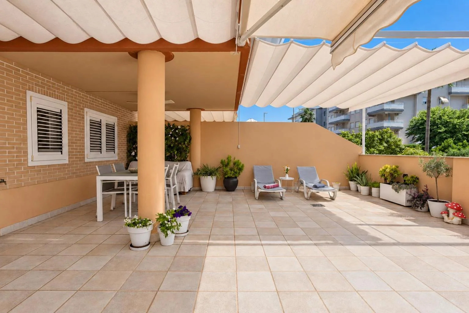 Terraza amplia con tumbonas y toldo